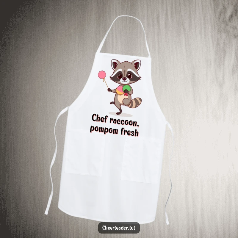 Funny raccoon apron showing a curious animal balancing with pom-poms, ideal for kitchen use with humorous cheer.