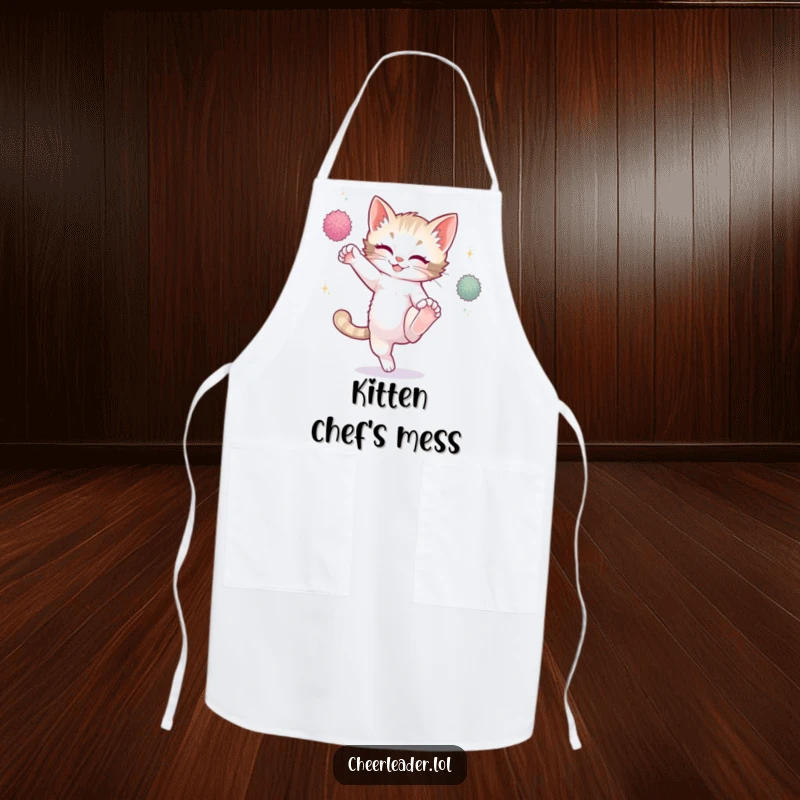 Funny playful kitten high kicking with sparkling pom-poms, wearing a kitchen apron, cooking humor.