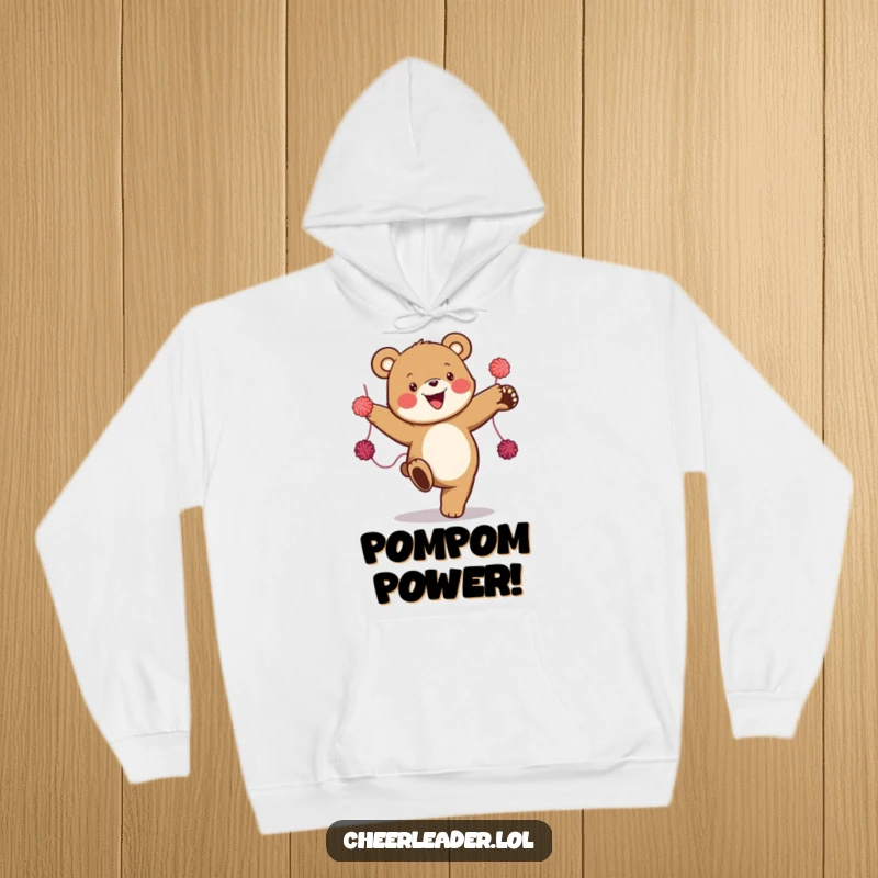 Funny hoodie featuring a happy bear performing a high kick with colorful yarn pom-poms, radiating infectious energy and cheer.